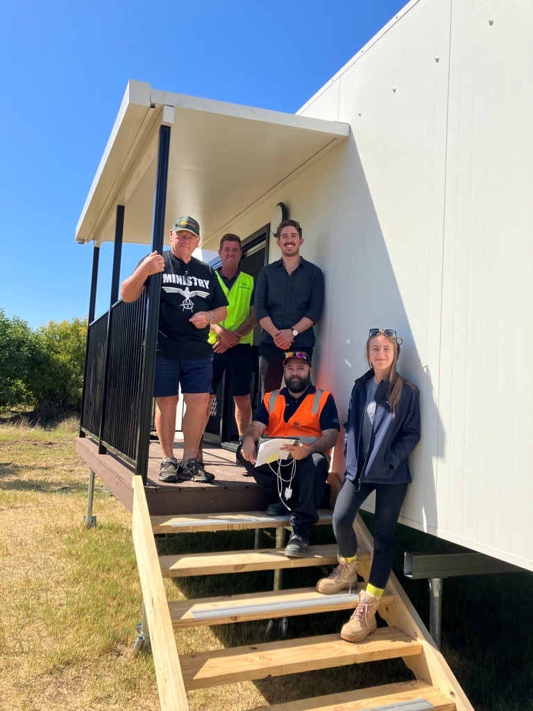 Eugowra Pod Homes - handover team on entry stairs to new pod home.jpg